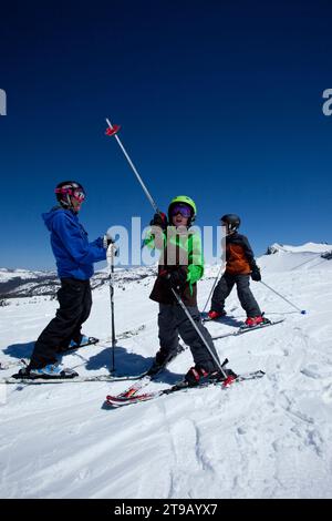 Zwei junge Skifahrer mit ihrem Skilehrer auf dem Gipfel des Berges. Stockfoto
