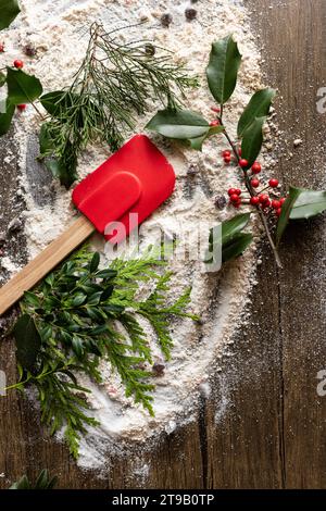 weihnachtliche Präsentation von Backzutaten und Utensilien mit grünen Pflanzen Stockfoto