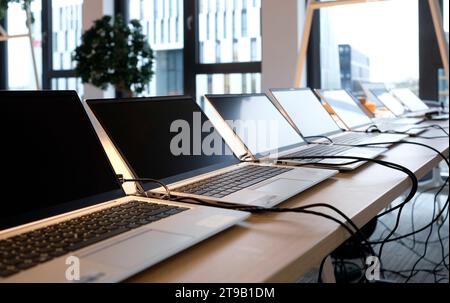 Reihe von Laptops, die für neue Mitarbeiter in einem Unternehmen vorbereitet und eingerichtet werden Stockfoto