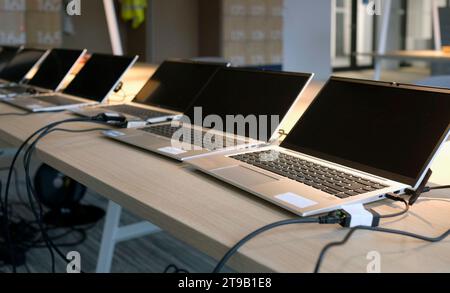 Reihe von Laptops, die für neue Mitarbeiter in einem Unternehmen vorbereitet und eingerichtet werden Stockfoto