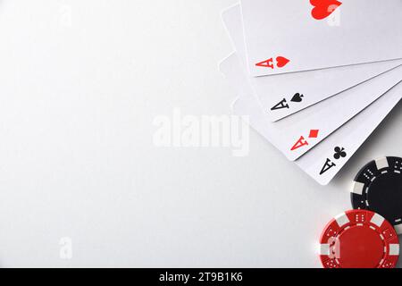 Hintergrund mit Karten von Assen und Chips für Wetten isoliert auf weißem Tisch. Draufsicht. Stockfoto