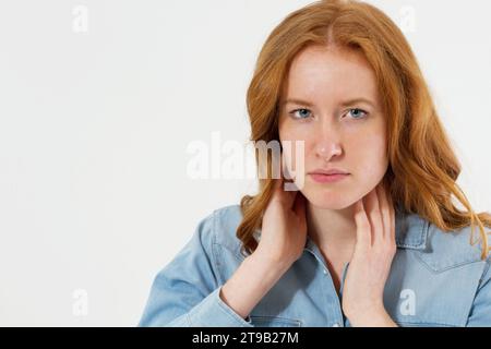 Weibliches Mädchen mit Nackenschmerzen Porträt aus nächster Nähe isolierter Kopierraum. Frau mit Nackenschmerzen, isolierte medizinische Aufnahme über weißem Hintergrund. Stockfoto