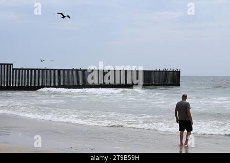 San Diego, CA, USA - 30. Juli 2023: Tourist in der Nähe der USA Mexico Border Wall im Border Field State Park Beach. Stockfoto