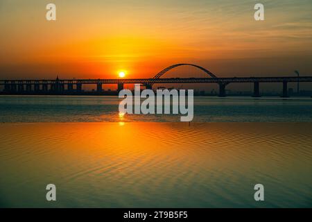 Sonnenaufgang auf dem Changjiang/Yangtze Fluss durch eine Stahlbrücke Stockfoto