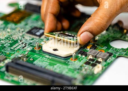 Ein Techniker repariert ein Notebook-Mainboard sorgfältig mit einer Vielzahl spezieller Werkzeuge Stockfoto