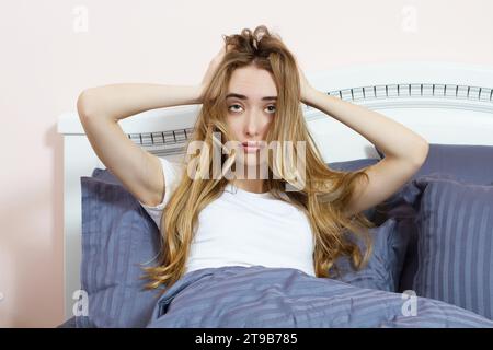 Depressive Frau, die morgens wach ist, ist erschöpft und leidet an Schlaflosigkeit. Leidende Mädchen unter Schlaflosigkeit. Stockfoto