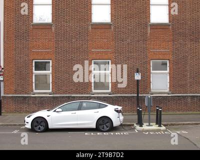 An Ladestationen für Straßenfahrzeuge in Leyton, London, Großbritannien. Ein Tesla-Auto, das an eine vom rat betriebene Ladestation für Elektrofahrzeuge angeschlossen ist. Stockfoto