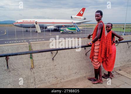 Tansania, Arusha - Maasai-Jungs schauen sich das Flugzeug am Flughafen Kilimandscharo an. Stockfoto