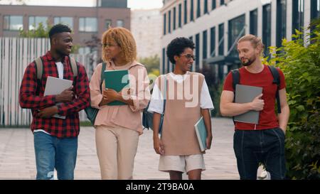 Verschiedene multirassische Studenten Jungen Mädchen Talk Walk in der Stadt Bildung multiethnische Freunde glücklich Talk Gespräch kommunizieren Walking College Stockfoto