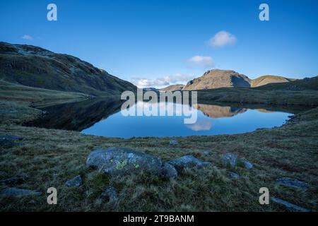 Die Berge Great End, Great Gable und Green Gable spiegeln sich in den Gewässern von Streusing Tarn im Lake District, Cumbria, England. Stockfoto