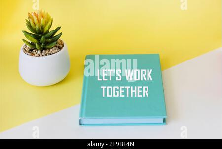 Arbeiten wir zusammen auf einem grünen Notizblock und einem gelb-weißen Hintergrund. Stockfoto