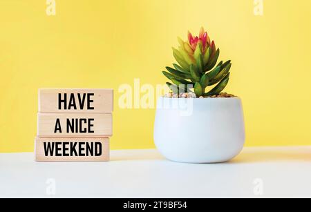 Inschrift auf Holzblöcken mit einer Blume auf weißem und gelbem Hintergrund Stockfoto