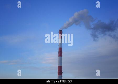 Rauchende Pfeifen, die Wolken vor dem Hintergrund des Sonnenuntergangs bilden. Luftverunreinigung durch Kohlendioxid. Umweltverschmutzung. Stockfoto