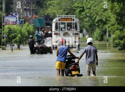 Colombo, Sri Lanka. November 2023. Menschen laufen durch eine überflutete Straße in Gampaha, Sri Lanka, 24. November 2023. Mehr als 5.000 Menschen, die mehr als 1.400 Familien angehören, sind nach wie vor von wetterbedingten Katastrophen in Sri Lanka betroffen, teilte das Disaster Management Center (DMC) am Freitag in einem Bericht mit. Quelle: Ajith Perera/Xinhua/Alamy Live News Stockfoto