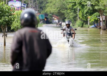 Colombo, Sri Lanka. November 2023. Ein Mann fährt ein Motorrad durch eine überflutete Straße in Gampaha, Sri Lanka, 24. November 2023. Mehr als 5.000 Menschen, die mehr als 1.400 Familien angehören, sind nach wie vor von wetterbedingten Katastrophen in Sri Lanka betroffen, teilte das Disaster Management Center (DMC) am Freitag in einem Bericht mit. Quelle: Ajith Perera/Xinhua/Alamy Live News Stockfoto