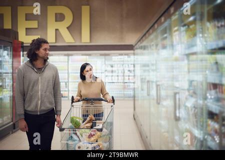 Ein Paar im Supermarkt, das zusammen einkaufen geht Stockfoto