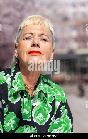 Stilvolle, reife Frau, die sich im Freien entspannt Stockfoto