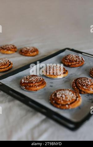 Hochwinkelansicht von gebackenen Zimtbrötchen auf Backblech Stockfoto