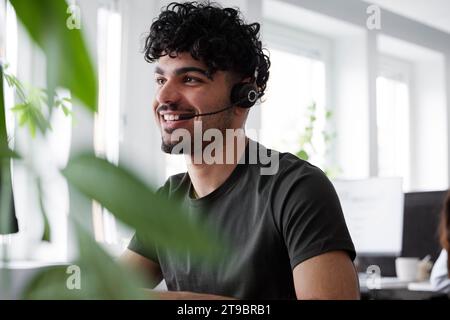 Junger Mann, der ein Headset trägt und wegblickt Stockfoto