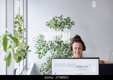 Frau mit Headset im Büro Stockfoto