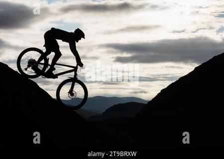 Silhouette Radfahrer, der auf Berg gegen Himmel fährt Stockfoto