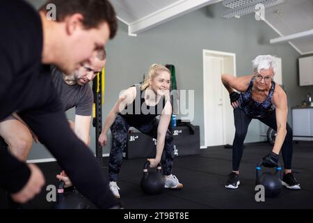 Menschen, die das Training mit Kettlebells in Turnhalle Stockfoto