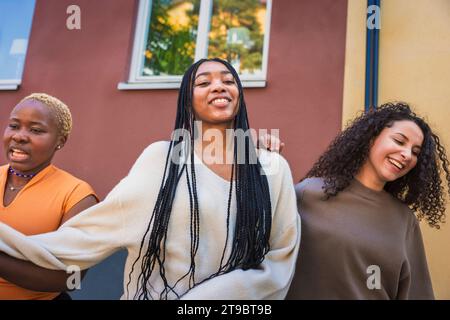 Lächelnde multirassische junge Freundinnen hängen am Wochenende zusammen Stockfoto