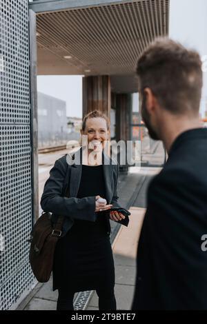 Glückliche Frau, die männlichen Kollegen ansieht Stockfoto