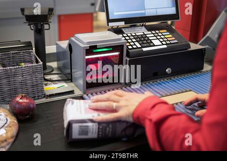 Abgeschnittene Hand einer Kassiererin an der Kasse des Supermarktes Stockfoto