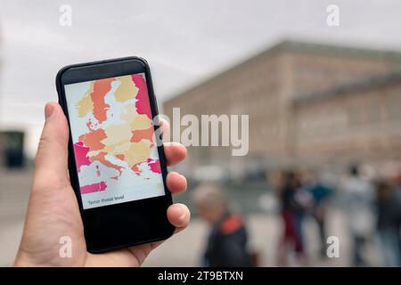 Abgeschnittene Hand einer Person, die in der Stadt ein Smartphone hält Stockfoto