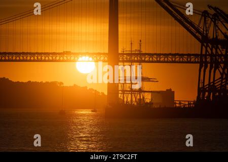 Ein faszinierender Sonnenuntergang mit goldenen Tönen auf einer majestätischen Wasserbrücke Stockfoto