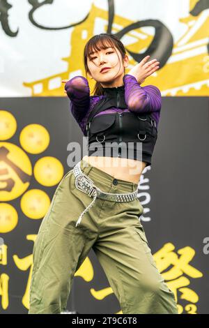 Junge Teenager-Tänzerin in Straßenkleidung, die beim jährlichen Yosakoi-Tanzfestival Kyusyu Gassai in Kumamoto auf der Bühne tanzt. Stockfoto