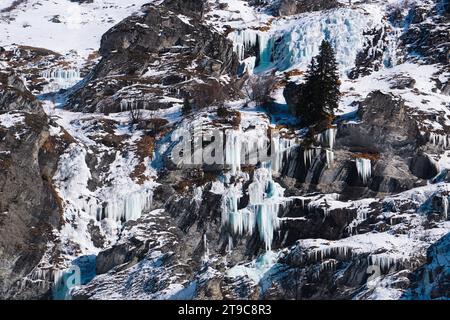 Eine gefrorene Landschaft in den französischen Alpen mit schneebedeckten felsigen Bergen mit markanten Eiszapfen, die ein winterliches Spektakel schaffen. Stockfoto