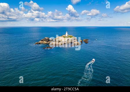 Aus der Vogelperspektive auf das Boot, das sich dem Leuchtturm Godrevy und der Insel nähert, St Ives Bay, Cornwall, England. Frühjahr (Mai) 2021. Stockfoto