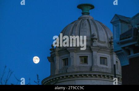 Brighton Großbritannien 24. November 2023 - der Mond steigt hinter dem Pepper Pot Gebäude in der Queens Park Gegend von Brighton auf nach einem hellen, aber kühlen Tag entlang der Südküste : Credit Simon Dack / Alamy Live News Stockfoto