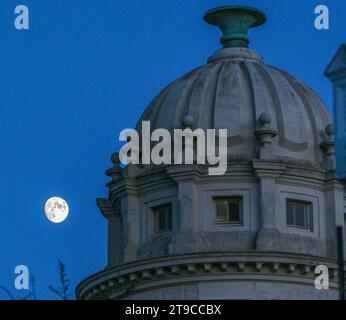 Brighton Großbritannien 24. November 2023 - der Mond steigt hinter dem Pepper Pot Gebäude in der Queens Park Gegend von Brighton auf nach einem hellen, aber kühlen Tag entlang der Südküste : Credit Simon Dack / Alamy Live News Stockfoto