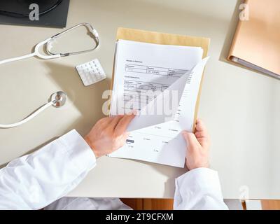 Männlicher Arzt, der die Papiere des Patienten in einem Krankenhaus durchsucht Stockfoto