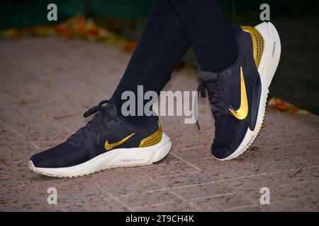 Mädchen tragen neue dunkelblaue Nike Sportschuhe Turnschuhe Laufen mit gelbem Swoosh Stockfoto