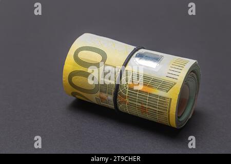Rolle mit 200-Euro-Banknoten auf schwarzem Hintergrund. Geldkonzept. Stockfoto