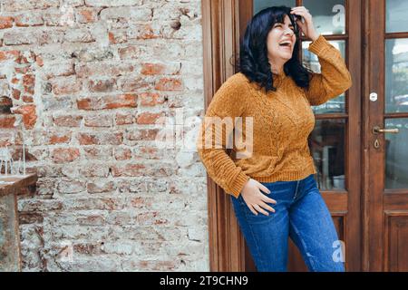 Die junge lateinamerikanische venezolanische Frau ist glücklich, lächelnd und verlässt den Coffee Shop nach dem Essen und ist zufrieden Stockfoto