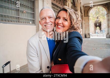 Ein liebevolles, mittelständisches Ehepaar, das Spaß hat, zusammen ein Selfie-Porträt zu einem romantischen Date zu machen. Echte Freunde mittleren Alters lächeln und lachen. Graue Haare Mann und Frau auf einem Wochenendausflug. Hochwertige Fotos Stockfoto