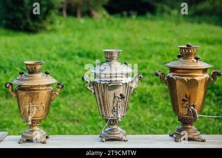 Drei Samovars auf dem Hintergrund von grünem Gras Stockfoto