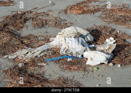 Strand in Norditalien nach einem heftigen Sturm. Plastik und Dosen kamen zusammen mit Algen aus dem Meer zurück. Verschmutzung und Abfall am Strand. Marine po Stockfoto