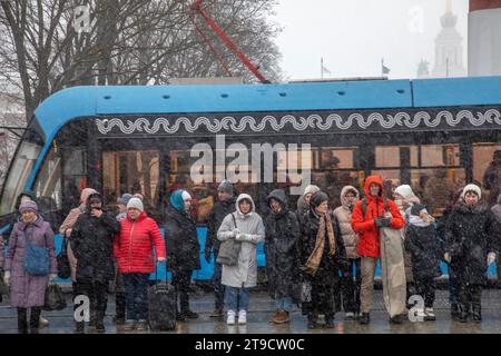 Moskau, Russland. November 2023. Die Menschen stehen an einer Fußgängerüberfahrt in der Nähe des Haupteingangs zum VDNKh-Messezentrum in Moskau vor dem Hintergrund einer vorbeifahrenden Straßenbahn entlang der Route, Russland Stockfoto