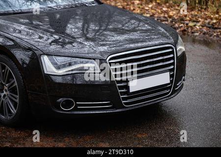 Modernes schwarzes Auto, das auf der Straße fährt, Stadtautos Hintergrund Stockfoto