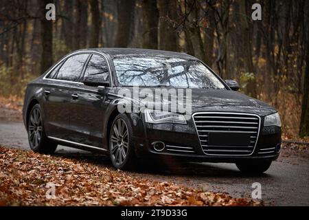 Modernes schwarzes Auto, das auf der Straße fährt, Stadtautos Hintergrund Stockfoto