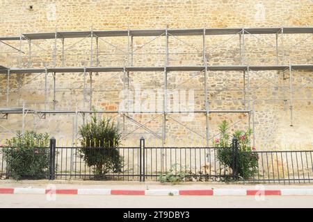 Nicht bearbeitetes Foto zeigt Gerüste für die Erneuerung und Renovierung von alten historischen Gebäuden Burgturmmauern Stockfoto