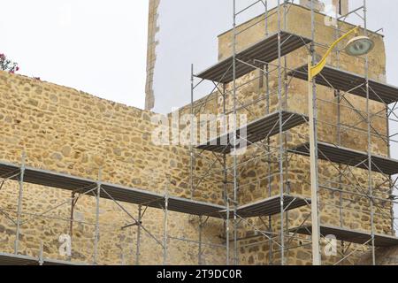 Nicht bearbeitetes Foto zeigt Gerüste für die Erneuerung und Renovierung von alten historischen Gebäuden Burgturmmauern Stockfoto