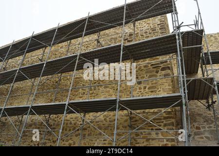 Nicht bearbeitetes Foto zeigt Gerüste für die Erneuerung und Renovierung von alten historischen Gebäuden Burgturmmauern Stockfoto