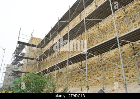 Nicht bearbeitetes Foto zeigt Gerüste für die Erneuerung und Renovierung von alten historischen Gebäuden Burgturmmauern Stockfoto